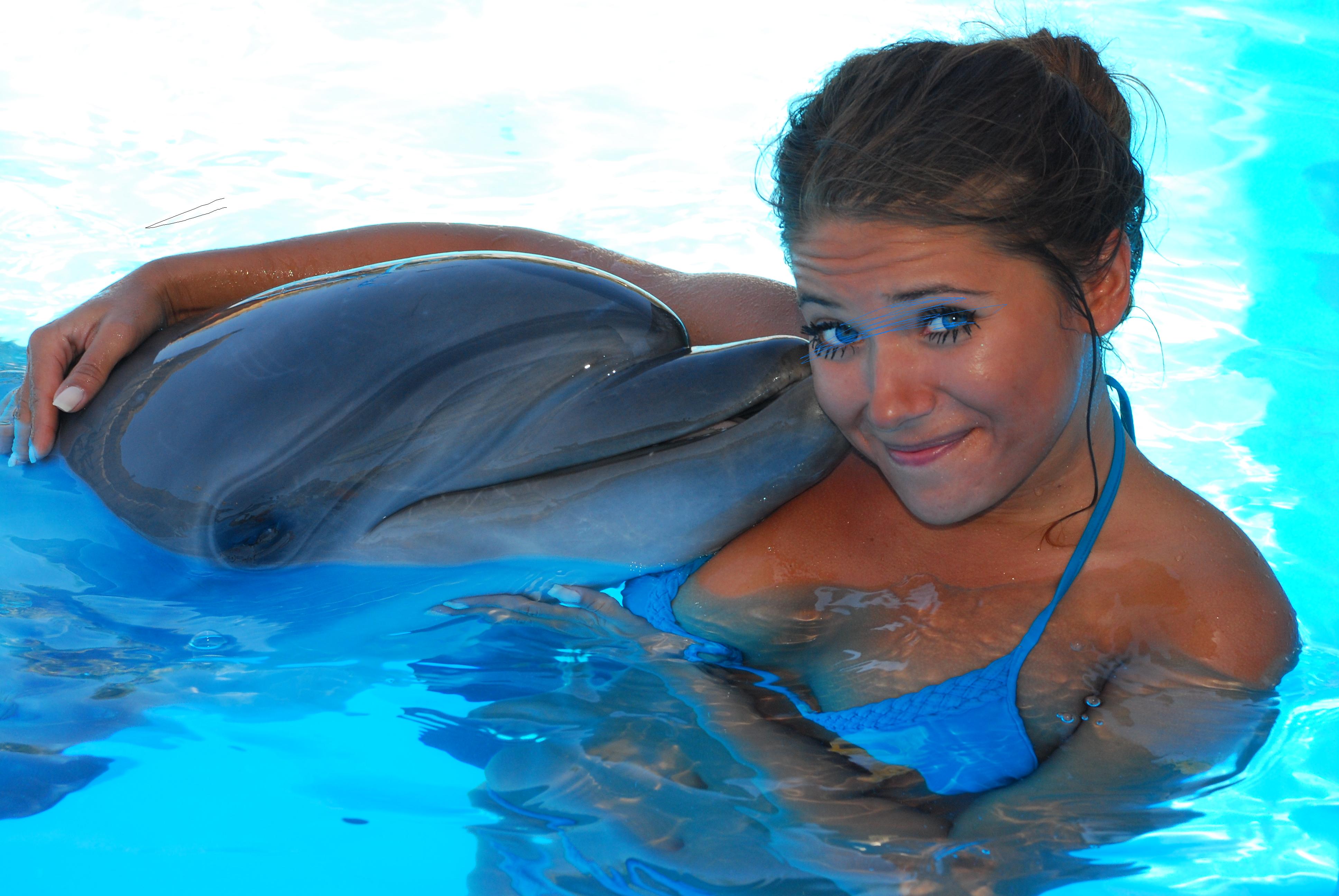 Женщина плавает с дельфинами